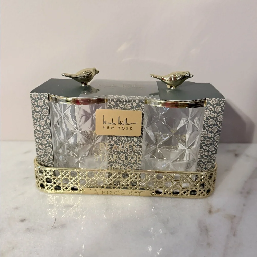 two-piece glass storage jar set with a gold bird lid and decorative tray.